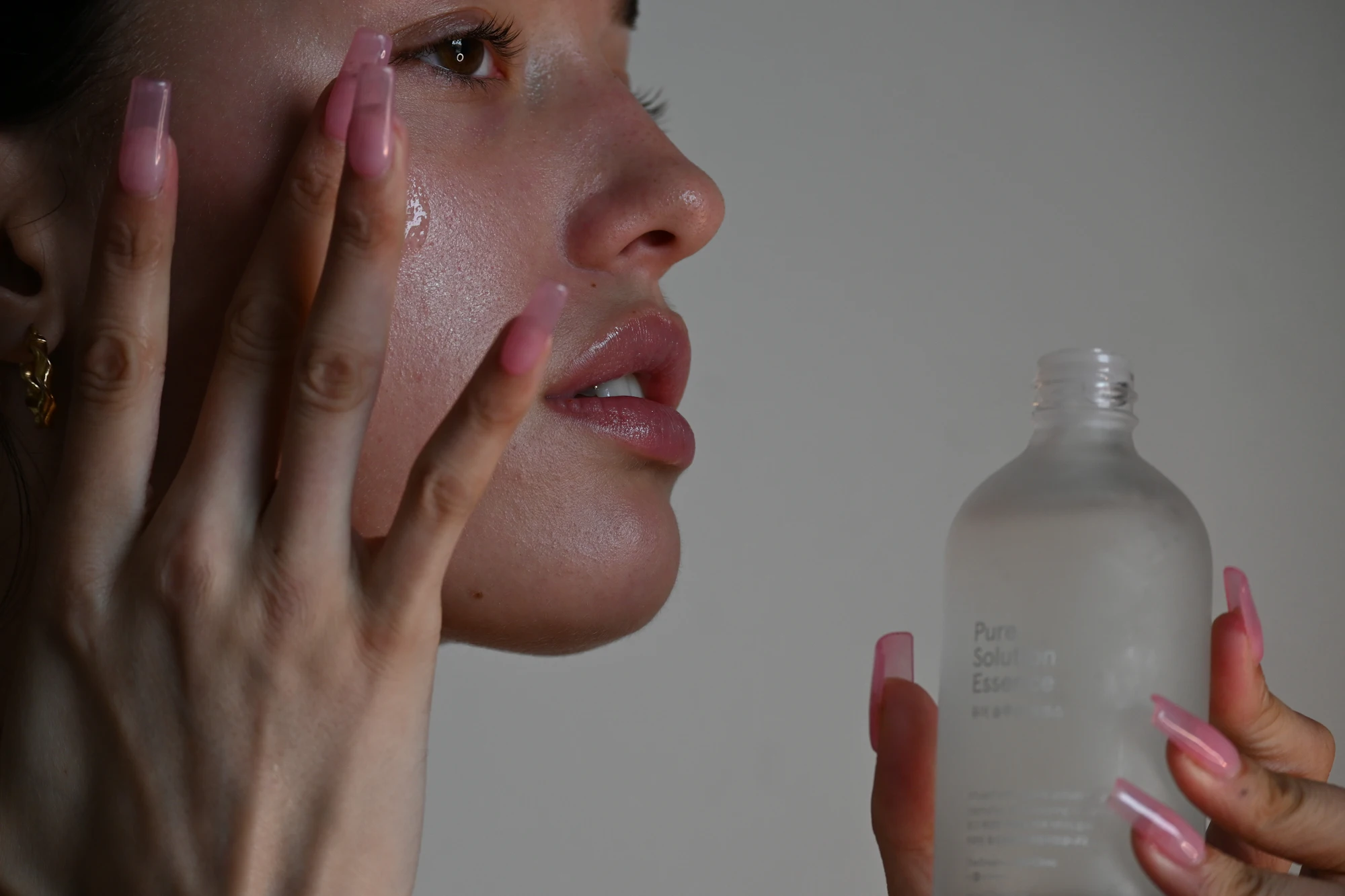 Applying serum to glowing skin