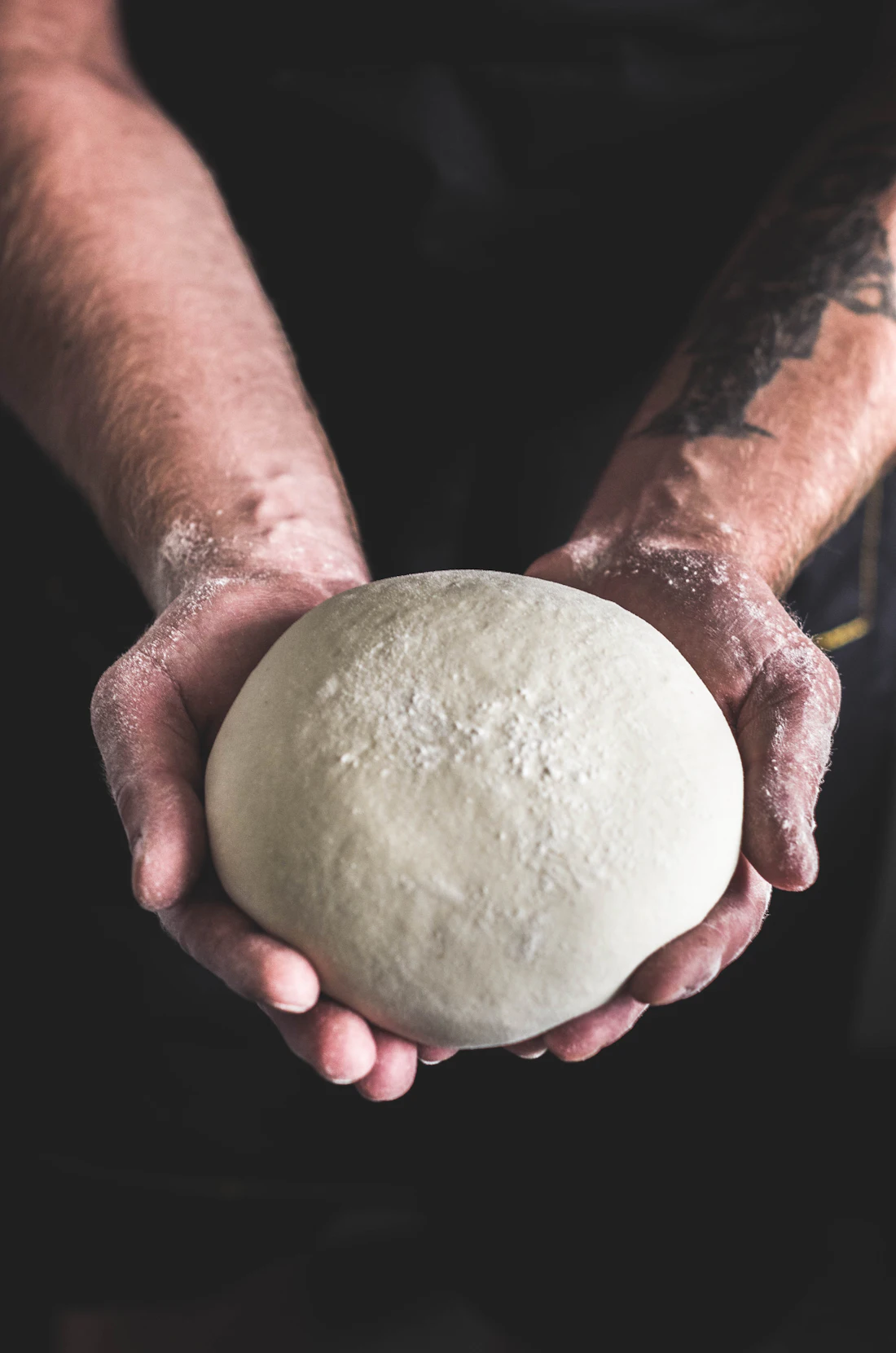 Pizzaiolo holding a dough ball