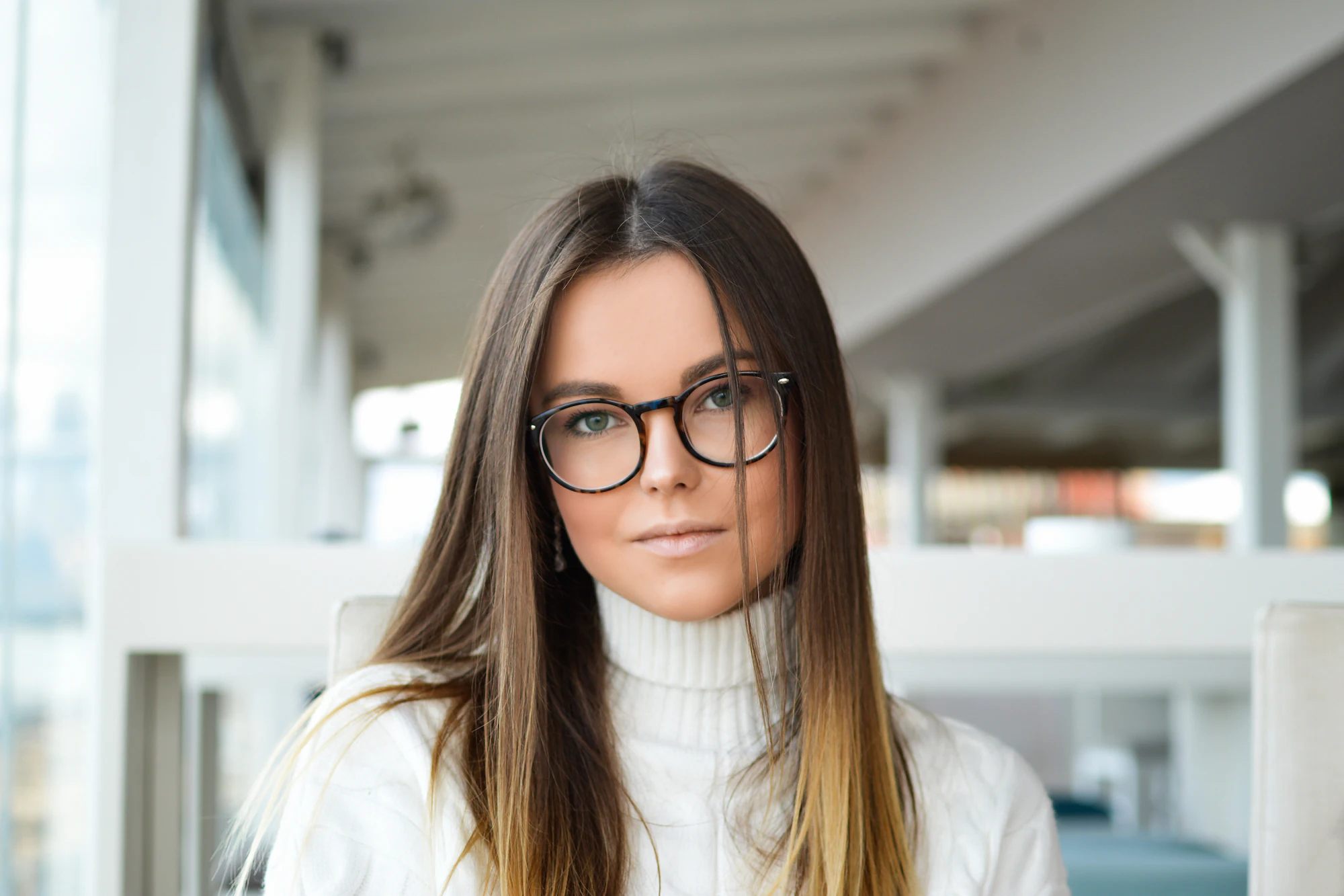 Woman wearing glasses by a window